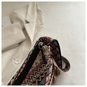 Dettaglio del tessuto jacquard bohémien, cerniera metallica e frange sulla borsa etnica