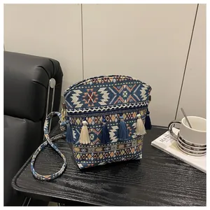 Dettaglio borsa a secchiello bohémien con motivi jacquard etnici e nappe blu a frange