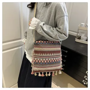 Close-up of bohemian crossbody bag with geometric jacquard fabric and colorful tassels