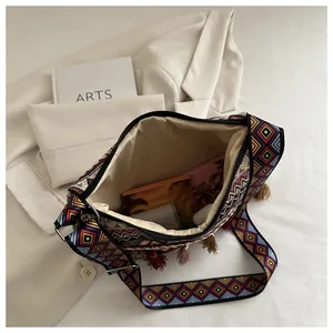 Dettaglio borsa a tracolla boho con motivi colorati e decorazione a frange