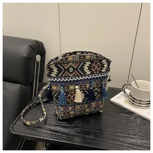 Dettaglio della borsa a secchiello boho intrecciata con motivi geometrici e frange