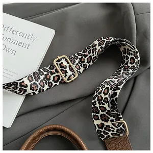 Detailaufnahme des gewebten Leopard-Riemens mit goldener Schnalle und Lederverbindung