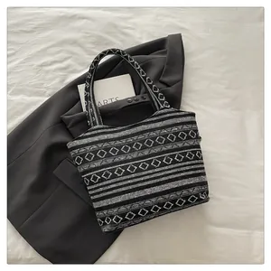 Dettaglio dei motivi geometrici jacquard e della trama intrecciata della borsa
