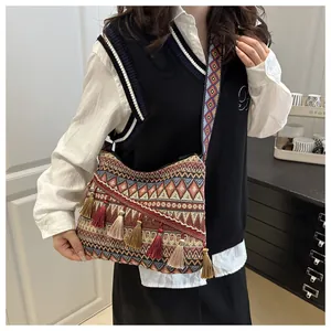 Dettaglio della borsa a tracolla jacquard bohémien con nappe colorate e motivi geometrici