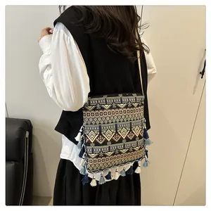 Close-up of bohemian woven crossbody bag showing geometric patterns and fringe tassels