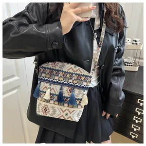 Dettaglio della borsa a secchiello jacquard etnico con nappe boho e tracolla larga tessuta