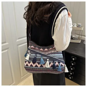 Dettaglio della borsa a tracolla boho con motivi jacquard etnici e nappe colorate