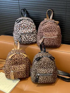Mini leopard print backpacks in four colors displayed on a stylish leather sofa
