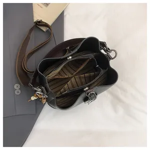 Vista dall'alto della borsa a secchiello con fodera a righe, zip e scomparto interno