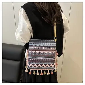 Detail of ethnic geometric crossbody bag featuring colorful tassels and woven patterns