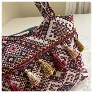 Dettaglio della borsa etnica con motivi geometrici intrecciati e nappe colorate