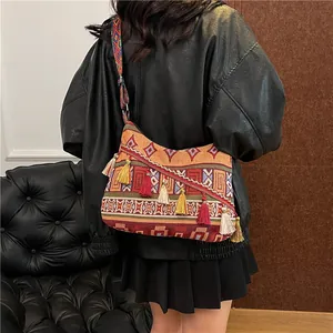 Borsa a spalla etnica intrecciata con motivi geometrici e nappine colorate vivaci