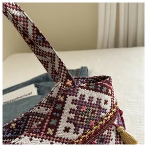 Dettaglio ravvicinato del tessuto jacquard boho intrecciato e nappa sulla borsa