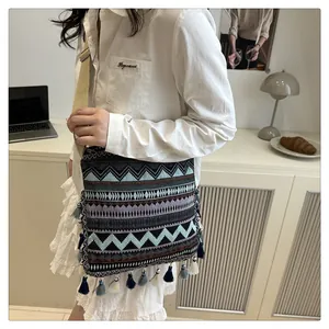 Detail of bohemian jacquard crossbody bag with colorful tassels and canvas strap