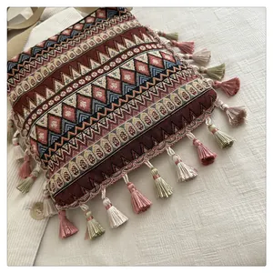 Detailed close-up of woven geometric patterns and colorful tassels on ethnic crossbody bag