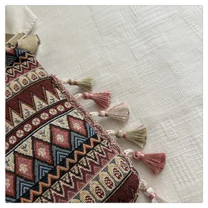 Detailed macro view of bohemian geometric woven fabric with colorful tassel fringe