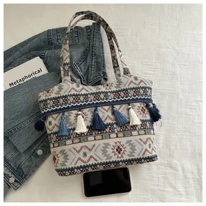 Dettaglio della borsa tote bohémien con motivi geometrici e rifiniture con frange blu