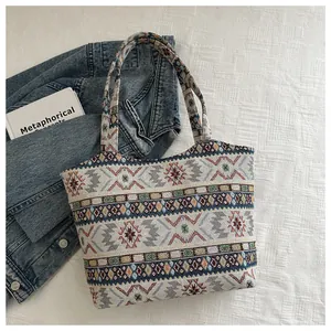 Dettaglio della borsa tote etnica con motivi geometrici colorati e nappe decorative