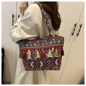 Dettaglio della borsa tote jacquard boho con nappe colorate e motivi geometrici