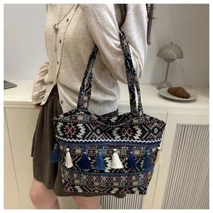 Dettaglio della borsa tote in jacquard con motivi geometrici e finiture con frange