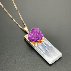 Vue macro d'un pendentif en gypse naturel avec amas de cristaux violets et chaîne dorée