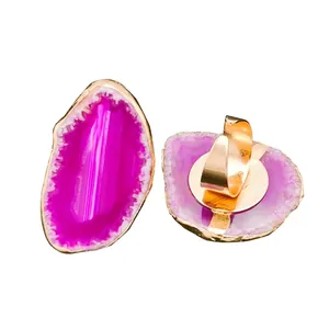 Natural magenta agate slice ring with adjustable gold-plated band on white background