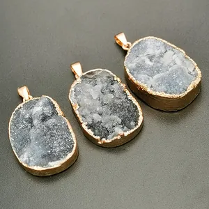 Macro-detail van natuurlijke geode-hangers met vergulde randen en grijze kristaltextuur
