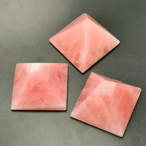Three-piece set of natural pink quartz crystal pyramids with polished stone textures