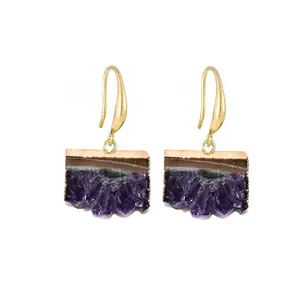 Détail des boucles d'oreilles en améthyste bohème avec placage à l'or et texture pierre naturelle