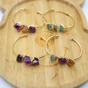 Detail von vier handgefertigten vergoldeten Armreifen mit natürlichen Amethyst-Edelsteinen