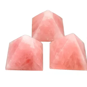 Set of three rose quartz crystal pyramids showing natural translucent textures on white back