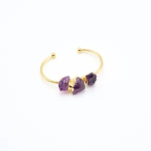 Detail eines vergoldeten Armreifs mit drei unregelmäßigen natürlichen violetten Amethysten