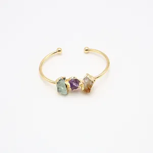 Detalle del brazalete dorado abierto con piedras naturales de amatista y citrino