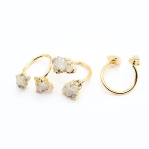 Détail macro de trois bagues dorées ajustables avec pierres de cristal blanc brut