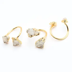 Gros plan d'une bague ouverte dorée ornée de cristaux de druse d'agate blanche naturelle