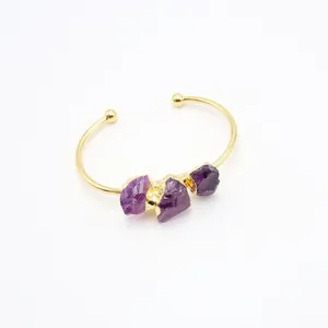 Goldener offener Armreif mit violetten Amethyst-Rohsteinen in minimalistischem Design