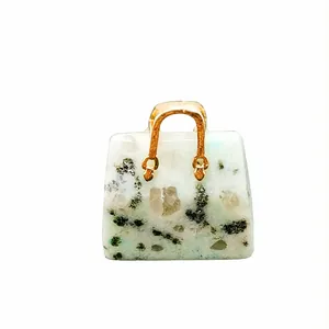Miniature blue aventurine crystal handbag pendant with golden handle on white background