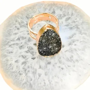 Detalle de racimo de cristal natural en forma de gota en un anillo ajustable dorado
