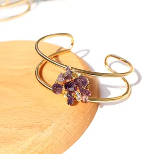 Detail van een dubbellaagse gouden armband met ruwe natuurlijke paarse amethistkristallen