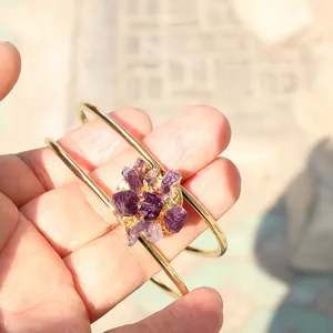 Gouden armband met paarse natuurlijke amethist kristal gedragen op de hand buiten