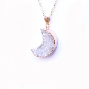 Detail of crescent moon crystal cluster pendant with rose gold plating on a fine chain