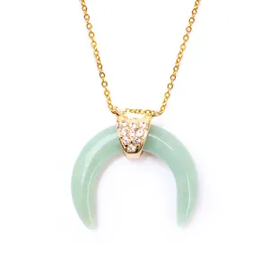 Close-up of light green crystal horn pendant necklace with pavé crystal detail and gold chain
