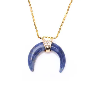 Detailed close-up of blue marble horn pendant with sparkling crystals on gold chain