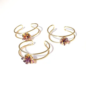 Macro-opname van drie gouden dubbelband armbanden met ruwe natuurlijke paarse amethist stenen