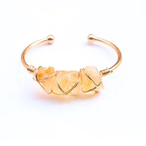 Detail van koperdraad gewikkelde armband met drie ruwe citrienstenen in boho-stijl
