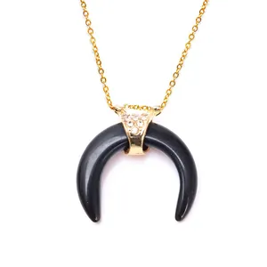 Detail of black crescent horn pendant with sparkling rhinestones and gold chain