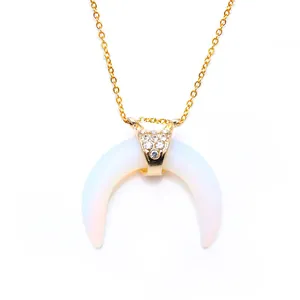 Macro detail of natural stone horn pendant with crystal studs on gold chain
