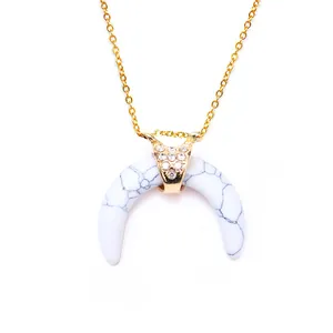 Detail of crescent pendant necklace with white stone texture and sparkling crystal inlay