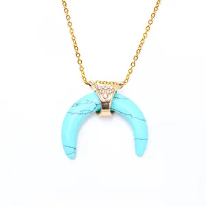 Detailed view of crescent turquoise pendant on a thin gold chain with inlaid diamonds