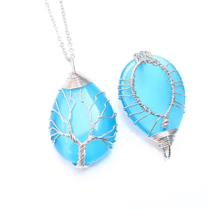 Détail macro du pendentif arbre de vie fait main en opale bleue et fil d'argent